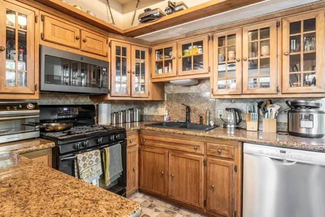 a kitchen with stainless steel appliances granite countertop a stove and a sink