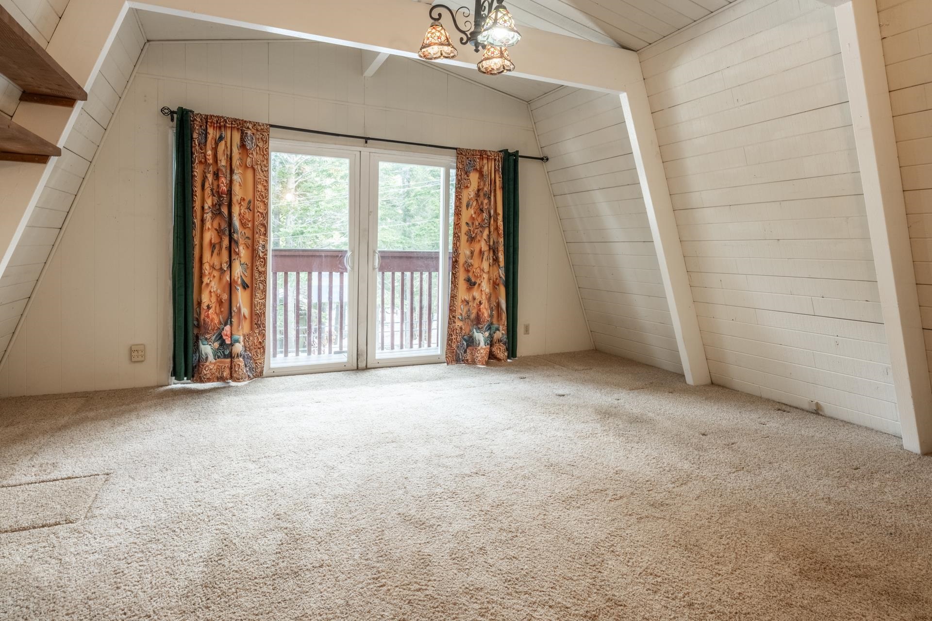 64 Mill Street Mammoth Lakes, CA 93546 - Photo 20 of 27 Spare room with carpet, wooden walls, and a chandelier