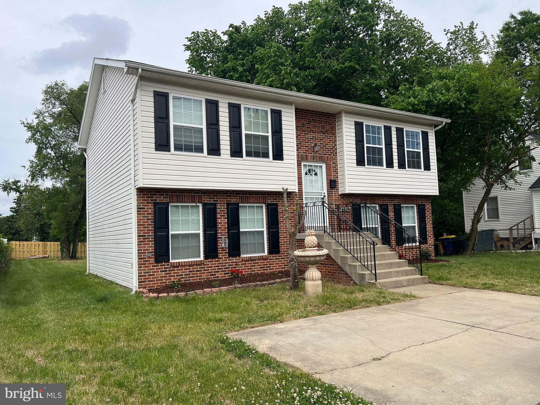 6604 Suitland Road Suitland, MD 20746 - Photo 1 of 27 a front view of a house with a yard and trees