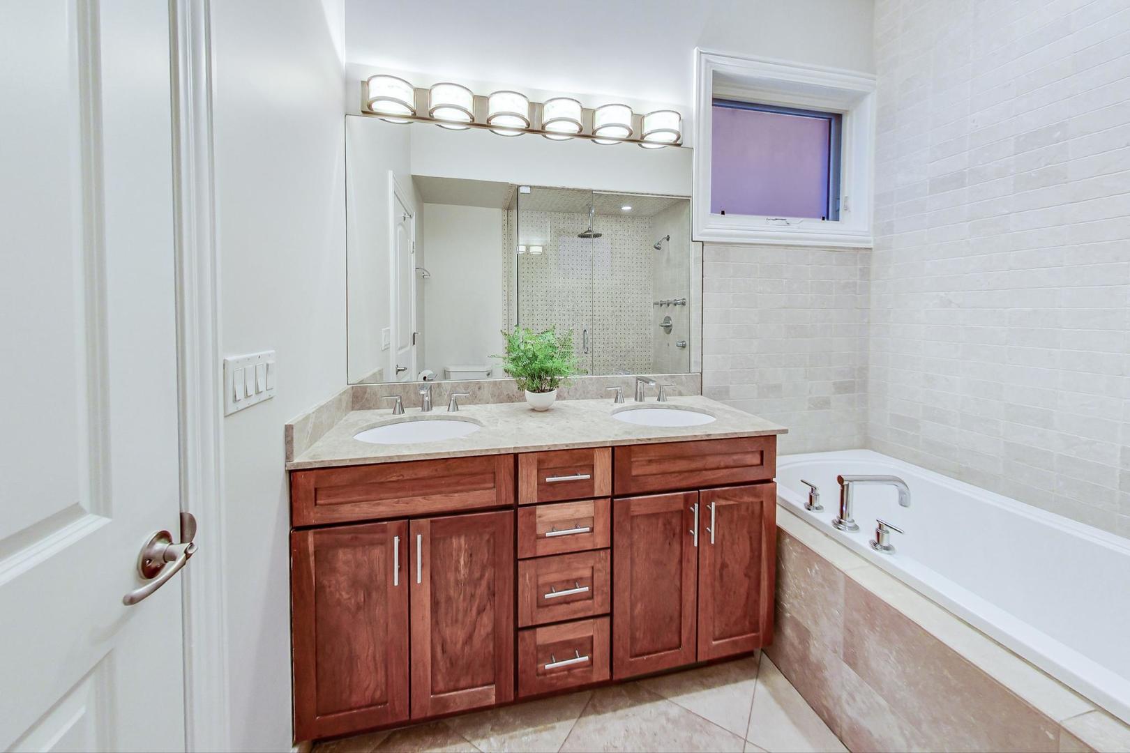 2448 West Augusta Boulevard, Unit 2 Chicago, IL 60622 - Photo 11 of 23 a bathroom with a granite countertop double vanity sink and mirror