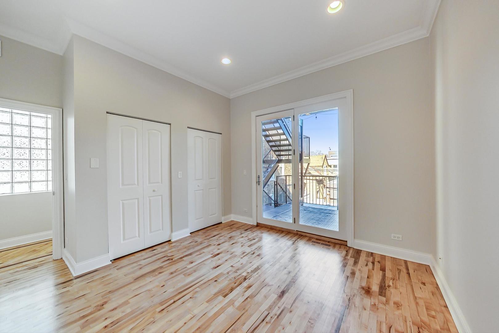 2448 West Augusta Boulevard, Unit 2 Chicago, IL 60622 - Photo 13 of 23 wooden floor in an empty room with a window