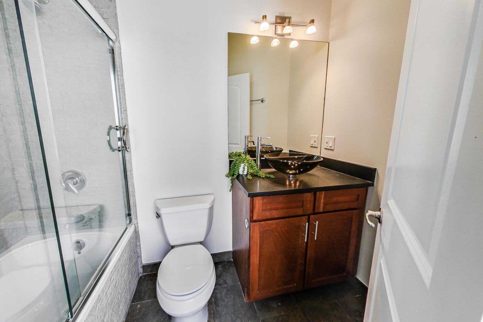 2448 West Augusta Boulevard, Unit 2 Chicago, IL 60622 - Photo 16 of 23 a bathroom with a toilet sink and mirror