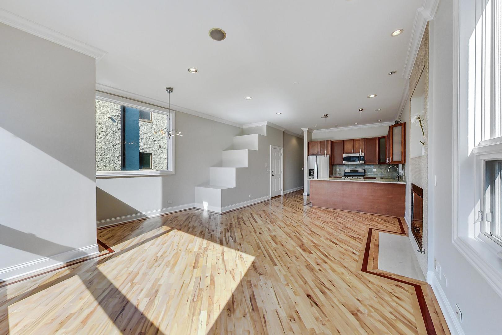 2448 West Augusta Boulevard, Unit 2 Chicago, IL 60622 - Photo 6 of 23 a living room with kitchen island granite countertop wooden floor and wide window