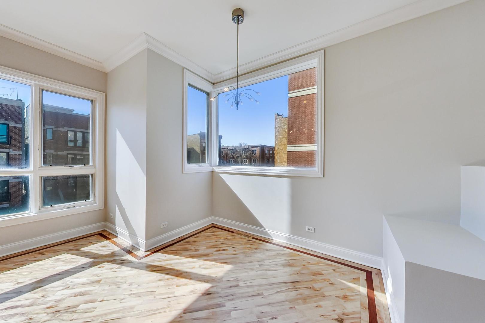 2448 West Augusta Boulevard, Unit 2 Chicago, IL 60622 - Photo 8 of 23 a view of an empty room with wooden floor and a window