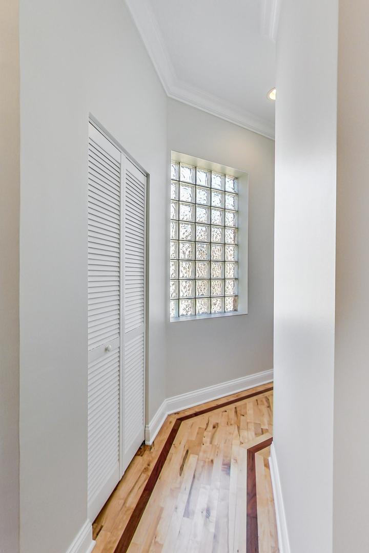 2448 West Augusta Boulevard, Unit 2 Chicago, IL 60622 - Photo 9 of 23 a view of an empty room with wooden floor and a window