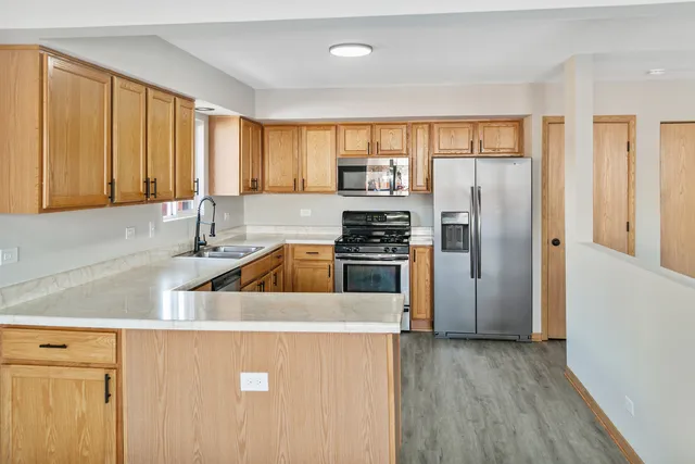 a kitchen with a refrigerator a sink and a window