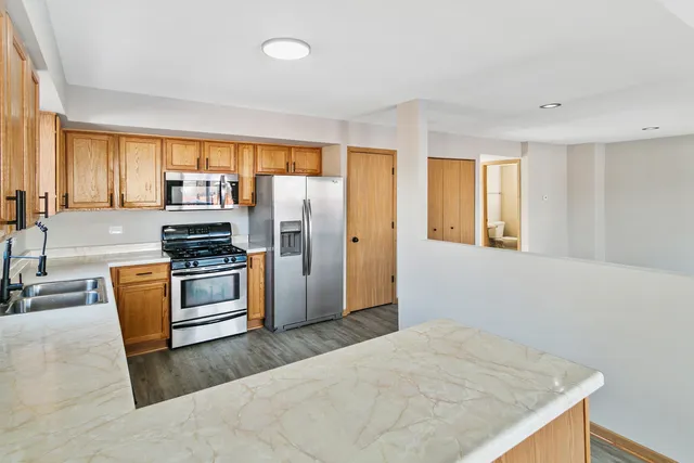 a kitchen with stainless steel appliances a refrigerator and a stove top oven