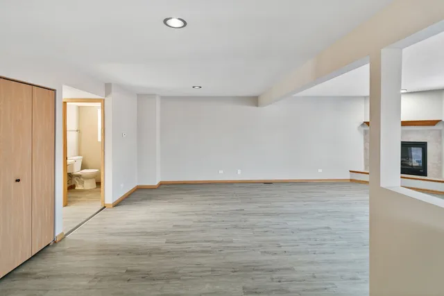 a view of an empty room with a fireplace and a window