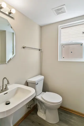 a bathroom with a sink mirror and toilet