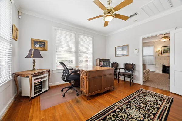 a view of a workspace with furniture and a window