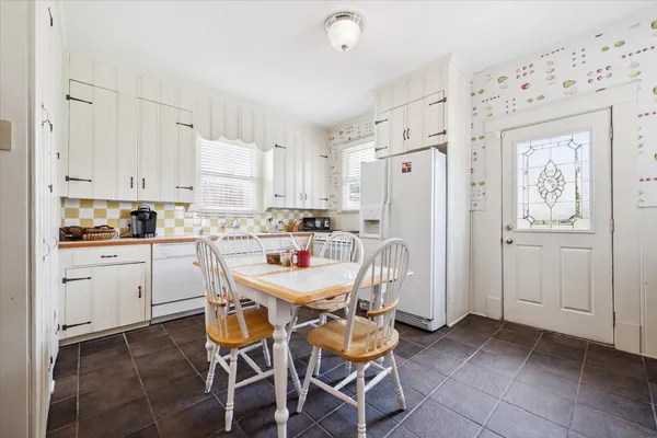 a kitchen with stainless steel appliances white cabinets and wooden floor