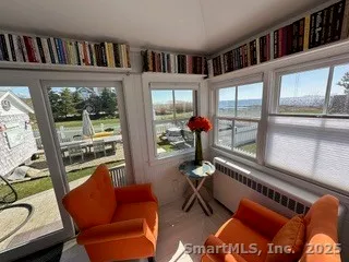 a living room with furniture a bookshelf and a large window