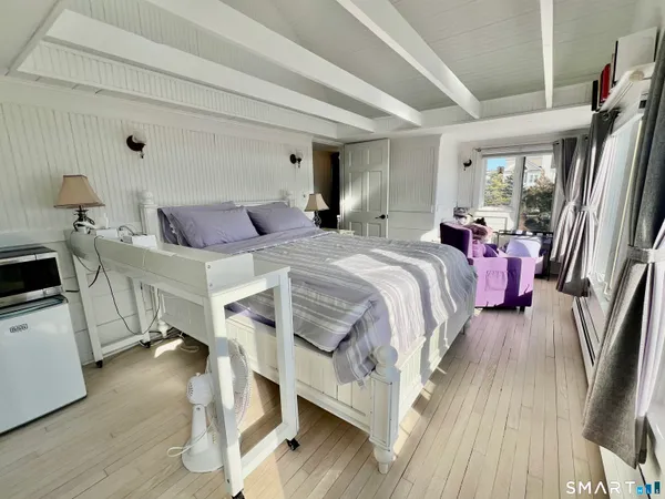 a bedroom with furniture and a flat screen tv