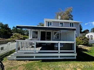 a view of a house with wooden deck and a yard