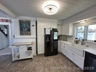 a kitchen with stainless steel appliances granite countertop a refrigerator a stove and a sink