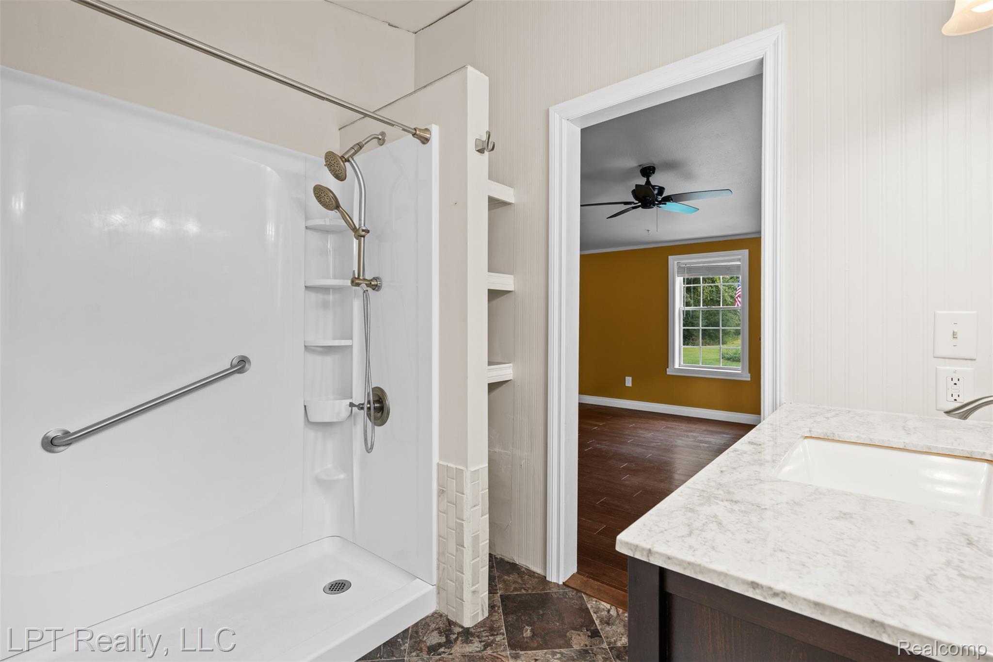 6271 East Potter Road Davison, MI 48423 - Photo 16 of 41 Full bathroom featuring a shower stall, vanity, dark stone finish floors, and a ceiling fan