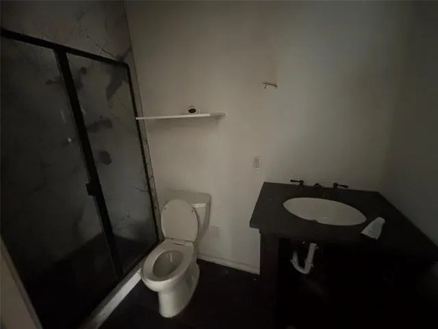 a bathroom with a granite countertop toilet and a sink