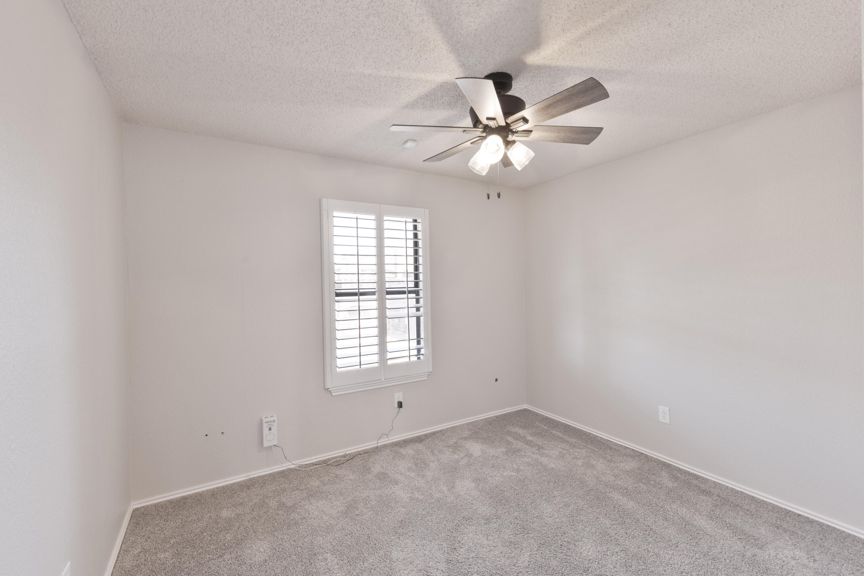 6036 71st Street Lubbock, TX 79424 - Photo 13 of 15 an empty room with windows and fan
