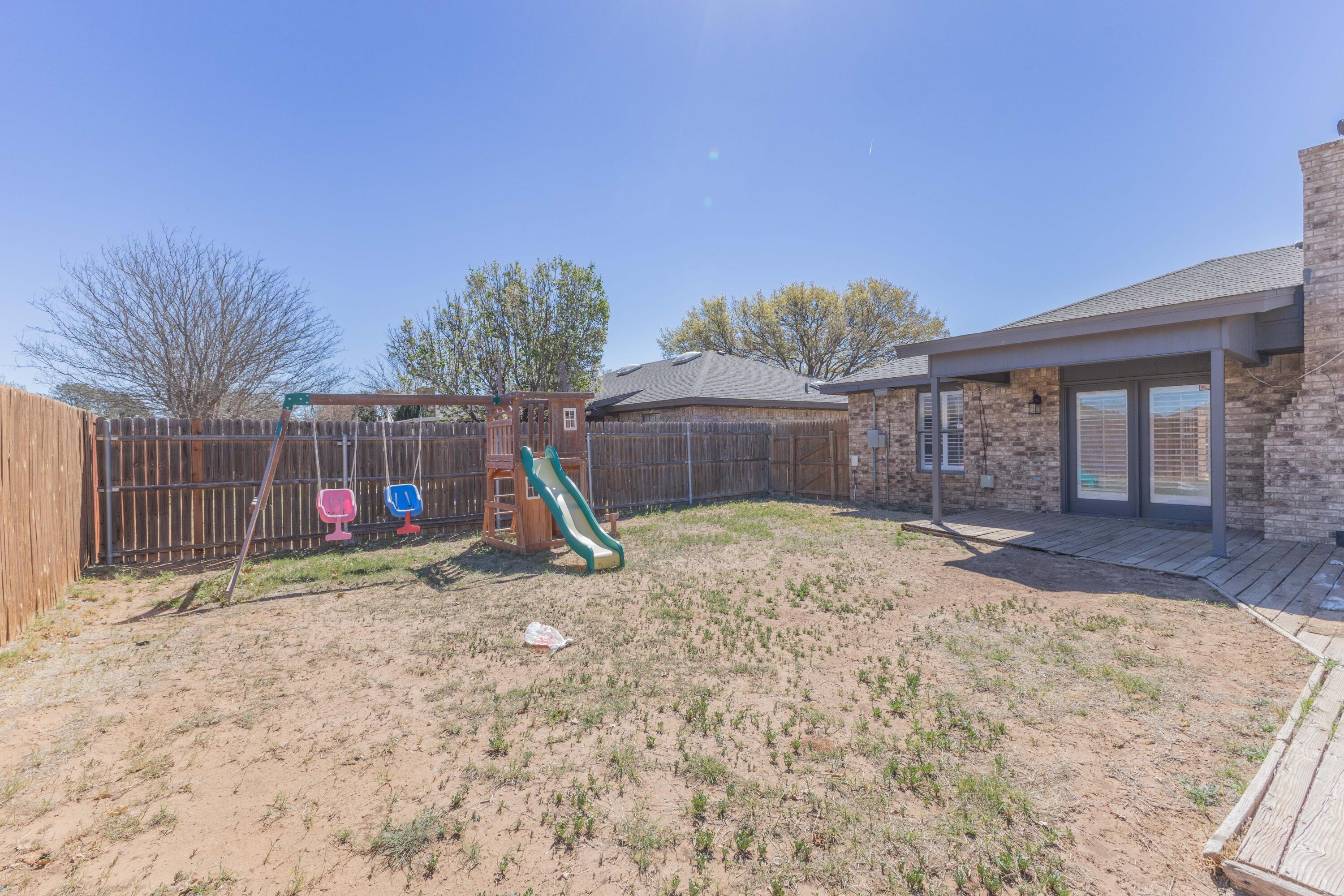 6036 71st Street Lubbock, TX 79424 - Photo 14 of 15 a view of a backyard with a tree