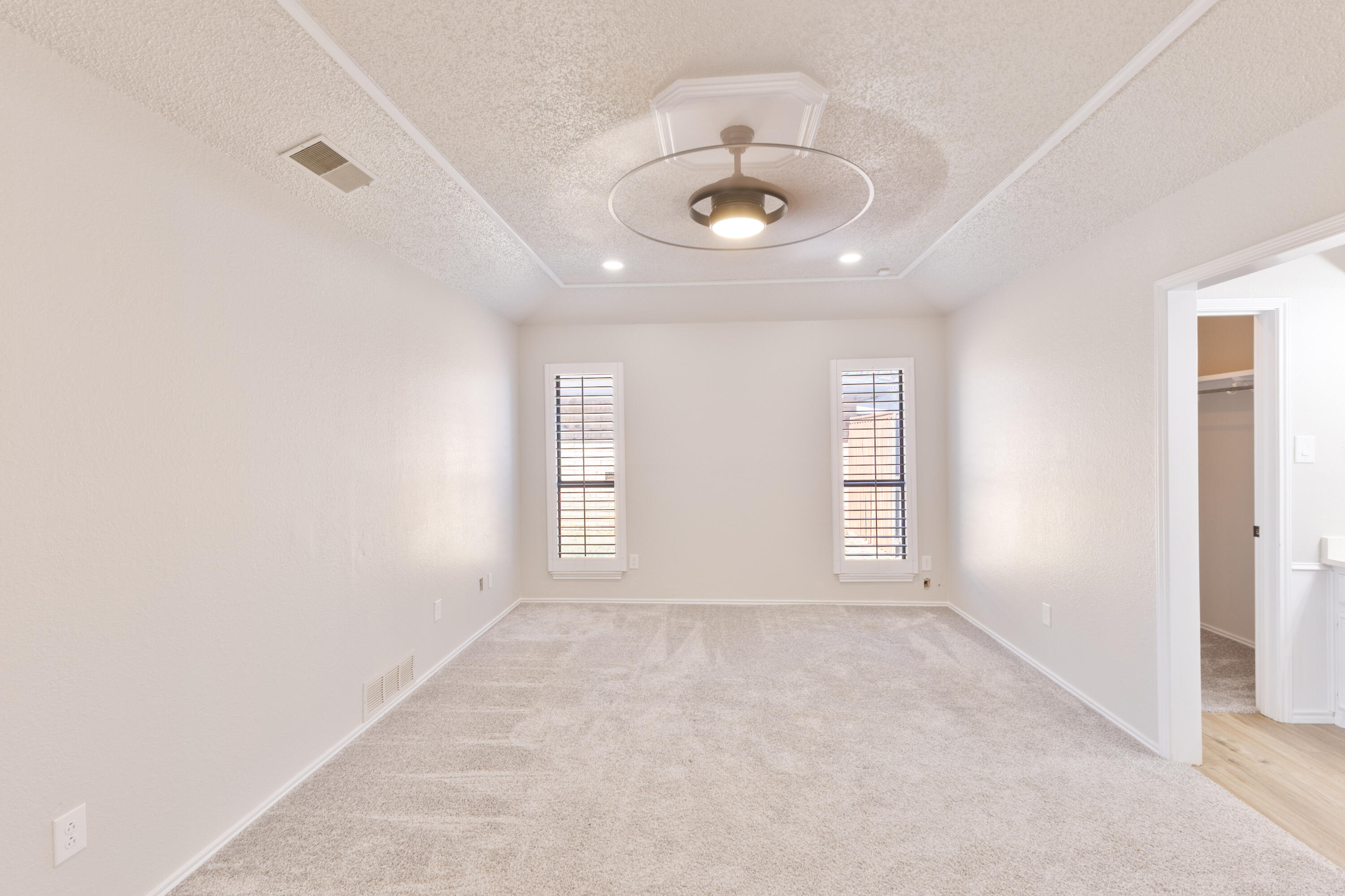 6036 71st Street Lubbock, TX 79424 - Photo 7 of 15 an empty room with windows and chandelier fan