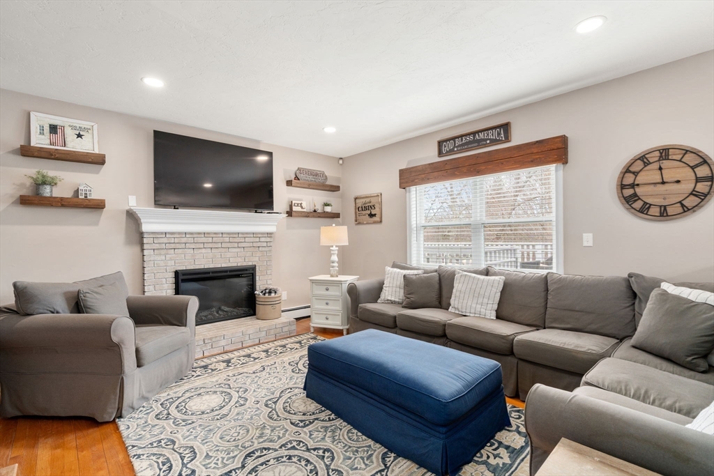 51 Albee Road Uxbridge, MA 01569 - Photo 21 of 42 a living room with furniture a flat screen tv and a fireplace