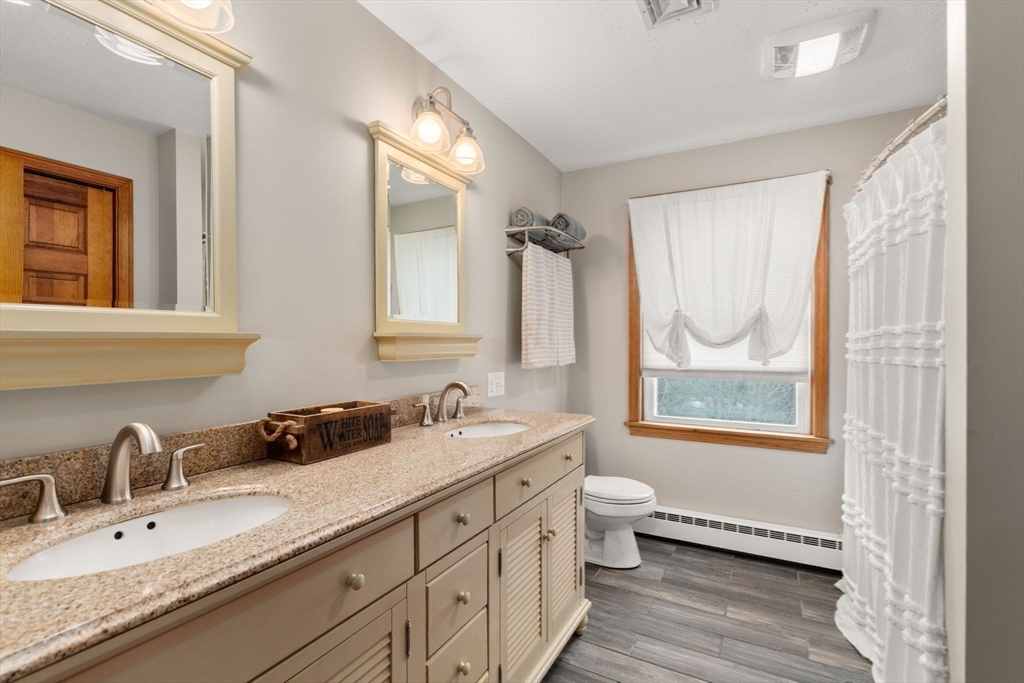 51 Albee Road Uxbridge, MA 01569 - Photo 35 of 42 a bathroom with a granite countertop double vanity sink a mirror and a window