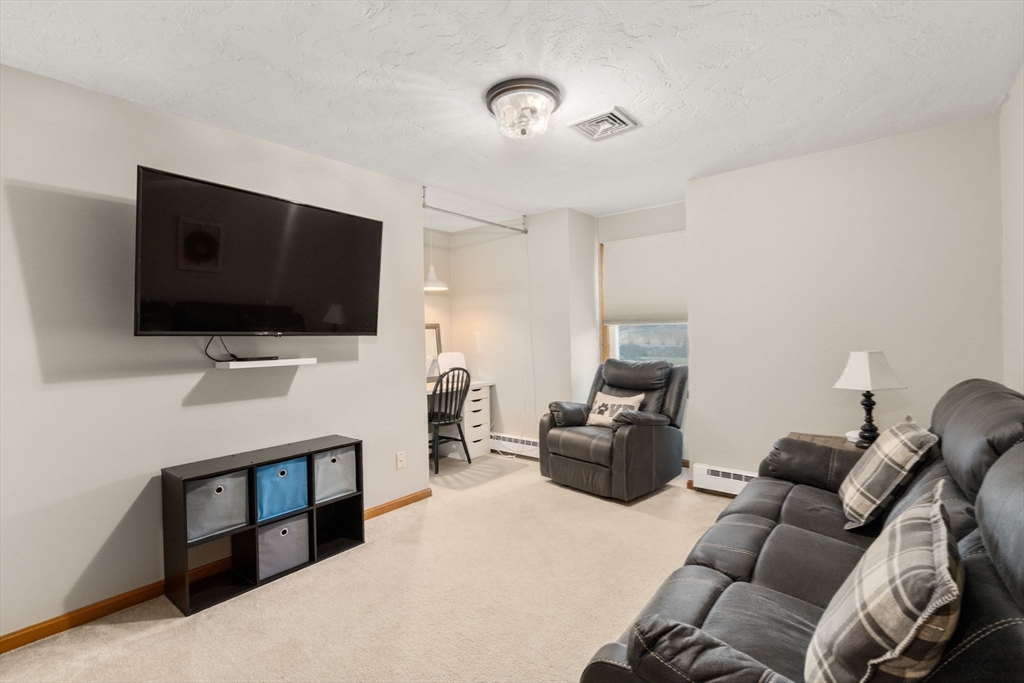 51 Albee Road Uxbridge, MA 01569 - Photo 36 of 42 a living room with furniture and a flat screen tv