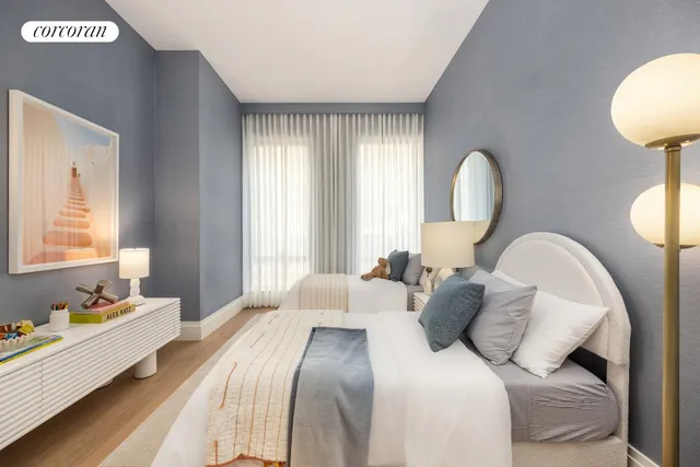 a large bed sitting in a room next to a chandelier