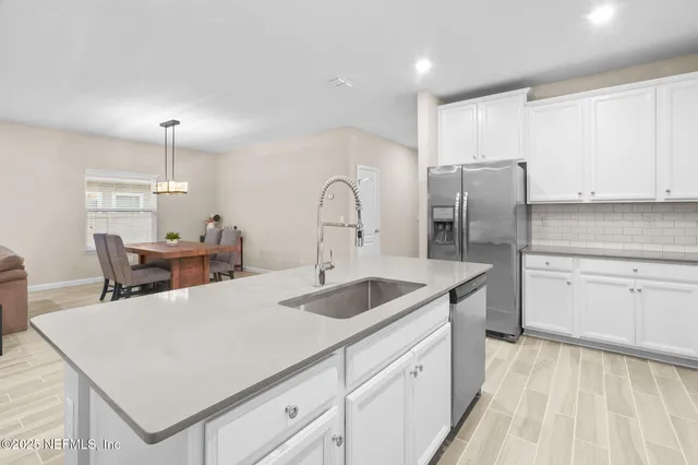 a kitchen with a sink refrigerator and cabinets
