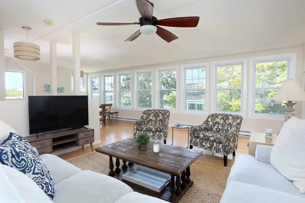 a living room with furniture a flat screen tv and a large window
