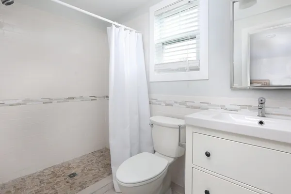 a bathroom with a granite countertop toilet sink and mirror