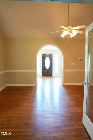 a view of a room with wooden floor and chandelier