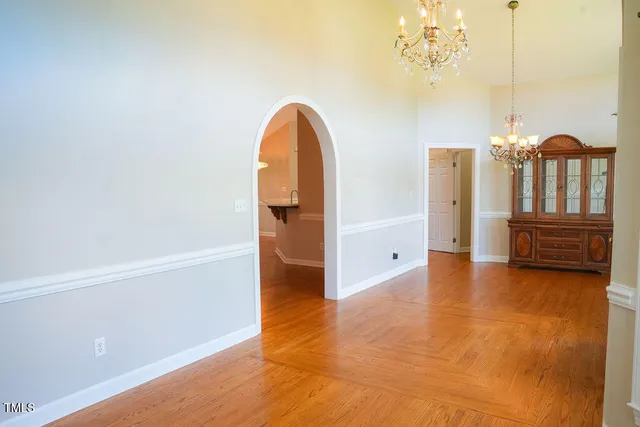 a view of a room with wooden floor and chandelier