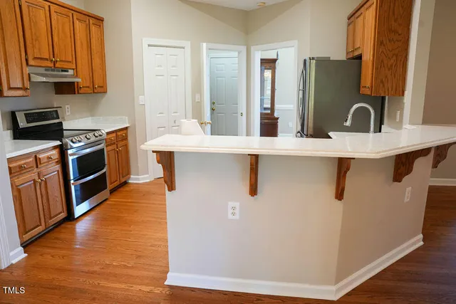 a view of an empty room with a fireplace and a chandelier fan