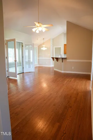 a view of a livingroom with wooden floor and a chandelier