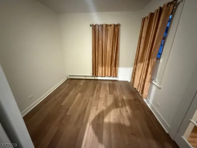 a view of a room with wooden floor and a window