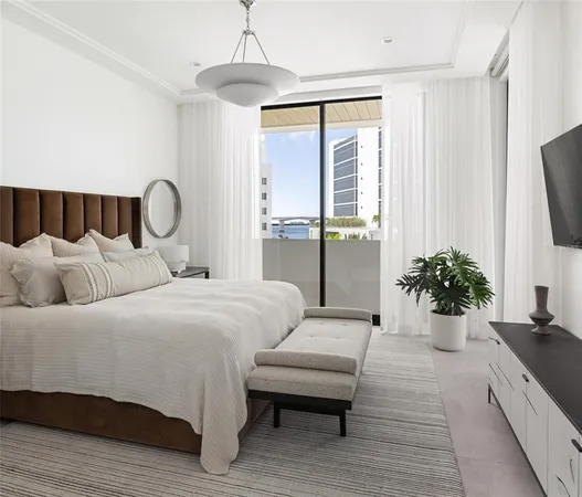 a bedroom with a large bed and a chandelier