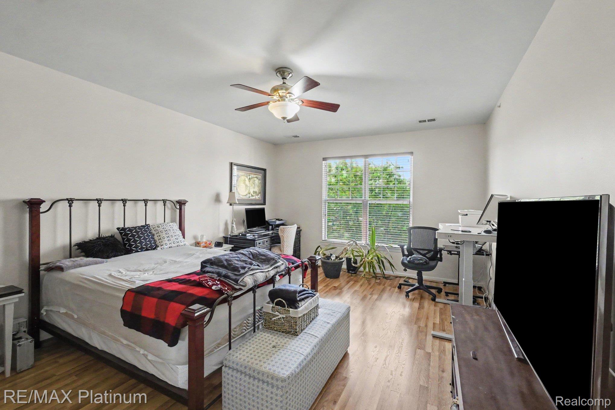 10217 Crossview Trail Howell, MI 48855 - Photo 16 of 26 Room with wood-finish flooring, a ceiling fan with integrated lighting, and a window with blinds