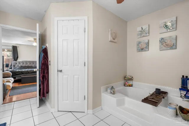 a bathroom with a tub and view of living room