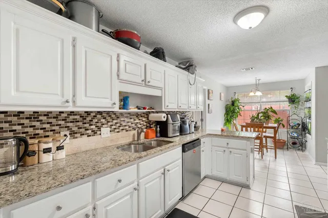 a kitchen with granite countertop a sink a stove and cabinets