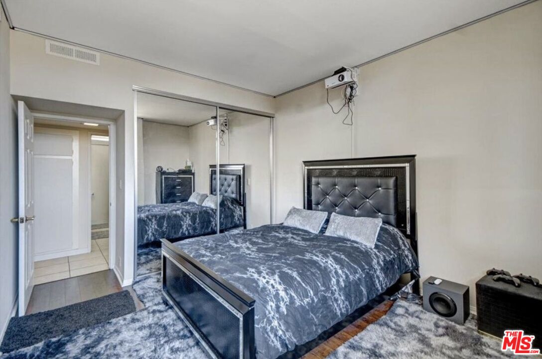 10535 Wilshire Boulevard, Unit 1701 Los Angeles, CA 90024 - Photo 12 of 18 a bedroom with a bed and a mirror on dresser