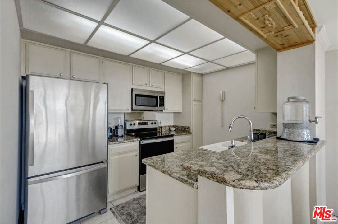 10535 Wilshire Boulevard, Unit 1701 Los Angeles, CA 90024 - Photo 7 of 18 a kitchen with stainless steel appliances granite countertop a sink a refrigerator and a granite counter tops