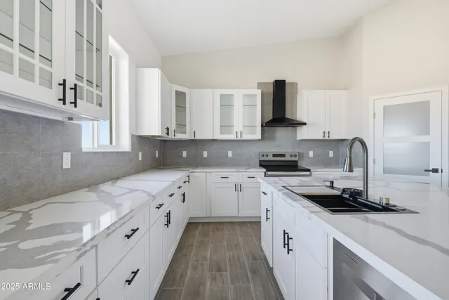 a kitchen with stainless steel appliances granite countertop a sink cabinets and wooden floor