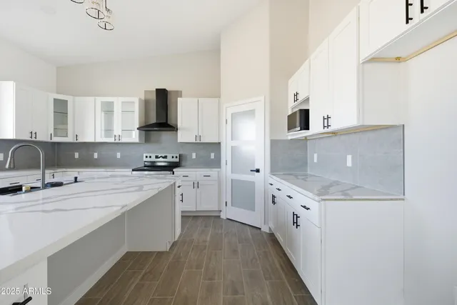 a kitchen with stainless steel appliances granite countertop a sink stove and cabinets