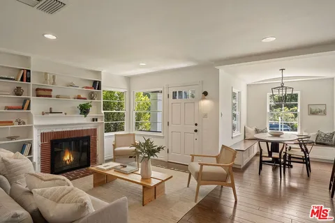 a living room with furniture a fireplace and a large window