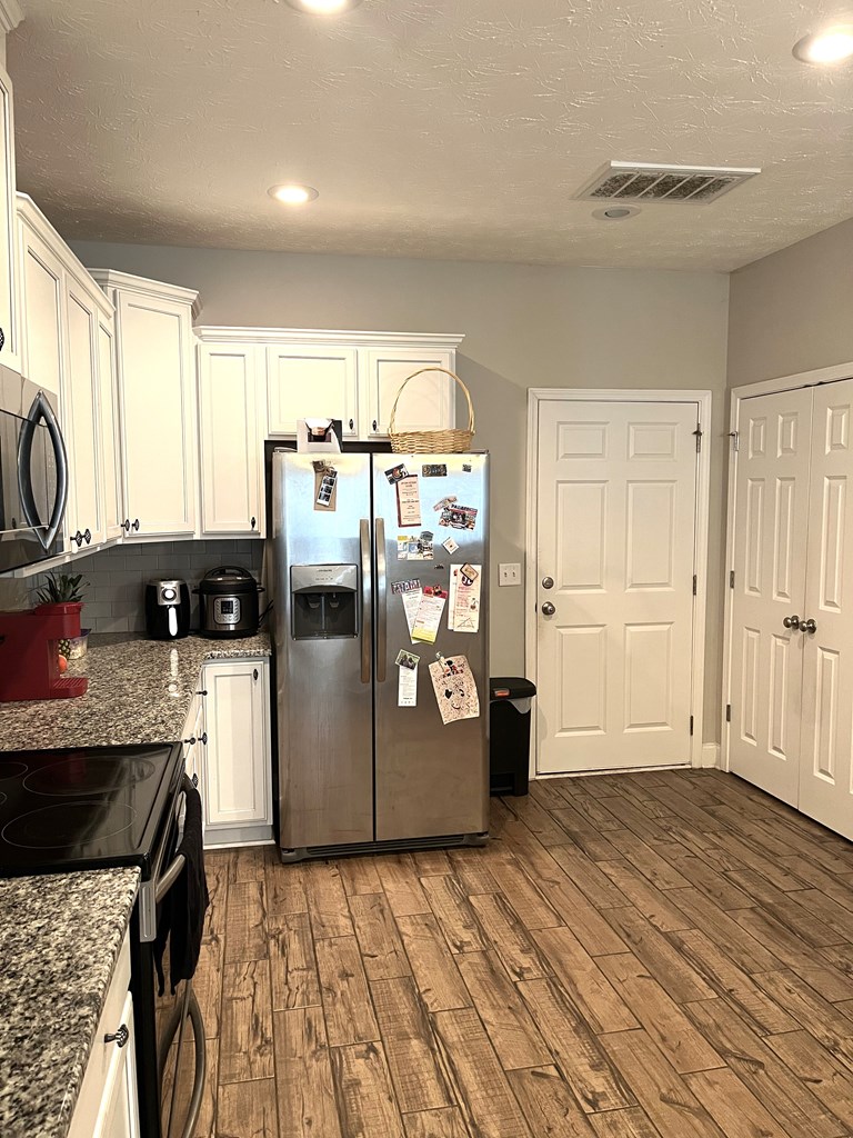 6067 Townes Way Columbus, GA 31909 - Photo 11 of 35 a kitchen with stainless steel appliances granite countertop a refrigerator a sink dishwasher a stove and white countertops with wooden floor