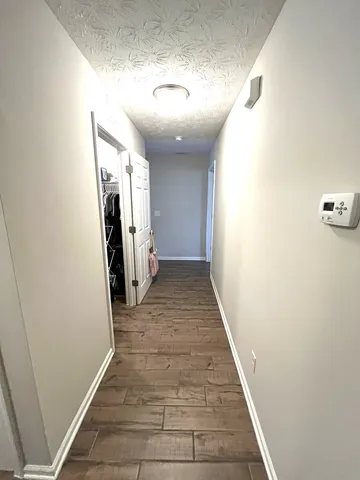 a view of a hallway with wooden floor and staircase