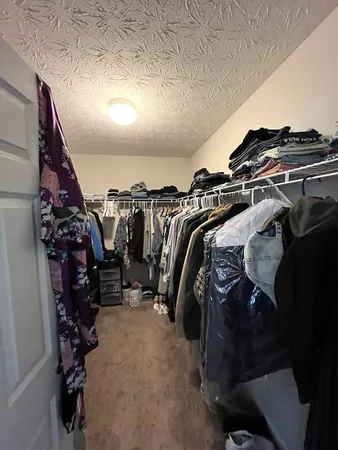 a view of walk in closet with clothes and shoes