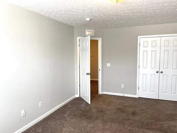 an empty room with windows and closet