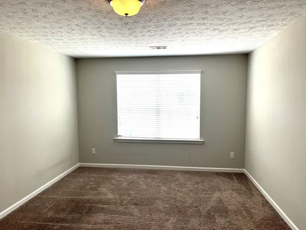 a view of a sink a window and cabinets